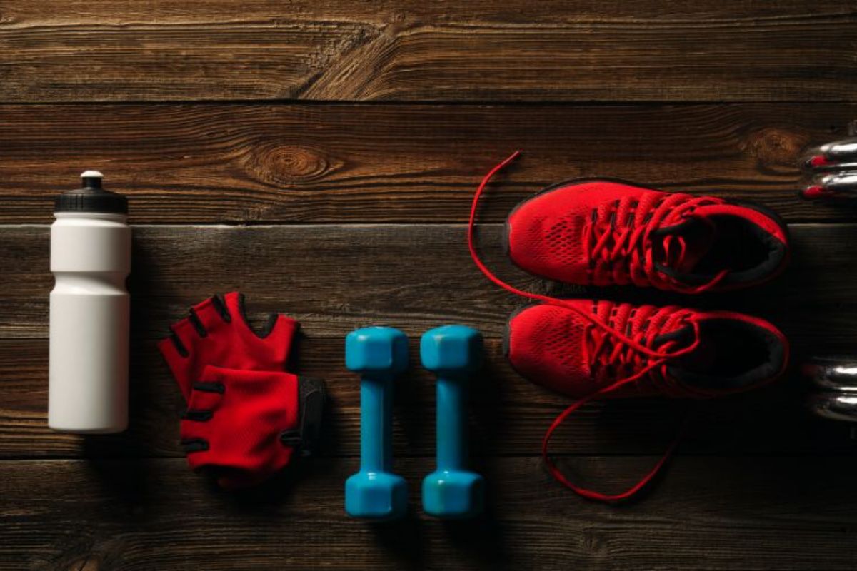 npl-supplements-top-view-fitness-equipment-and-supplements-on-wooden-floor-in-gym-fitness-background-with-pair-of-sneakers-min